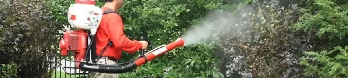 Mosquito control technician fogging shrubs and landscaping for mosquito treatment in Little Rock, AR